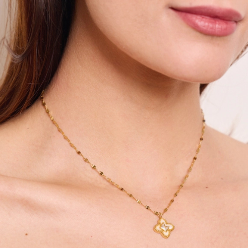 Goudkleurige ketting met parelmoer klaver en zirkonia gedragen om de hals