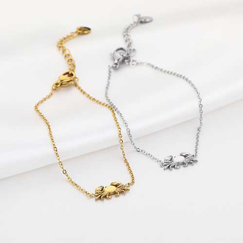 Dunne goud- en zilverkleurige RVS armband met minimalistisch krabbedel, subtiele beachlook.