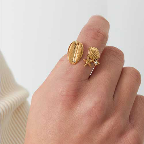 Goudkleurige roestvrijstalen ring met schelp, zeester en crystal steentje, past mooi om iedere vinger door de open voorkant.