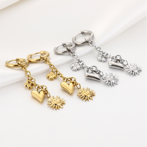 Set Sunnyheart oorbellen in goud- en zilverkleur met hangende zon-, hart- en bloembedels – speelse en symbolische sieraden op witte ondergrond.