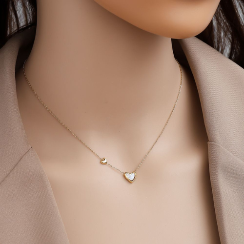 Goudkleurige, minimalistische ketting van roestvrijstaal met twee hartjes met contrast - gedragen om de hals