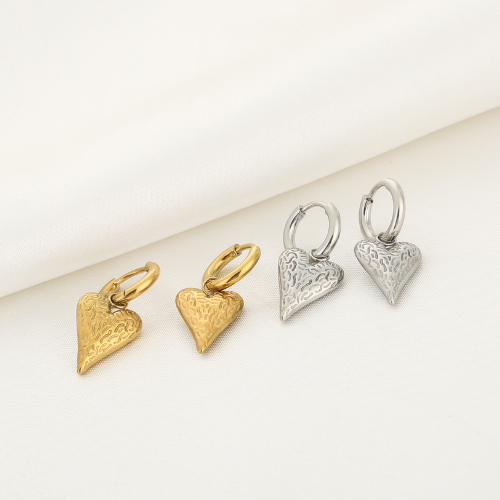 Set goud- en zilverkleurige Wildheart oorbellen liggend weergegeven – unieke hartvormige sieraden met speels textuurpatroon.