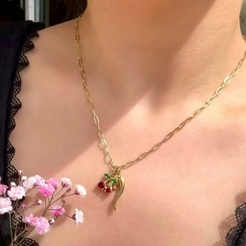 Goudkleurige bedelketting met zirkonia gekleurde hanger gedragen om de hals.