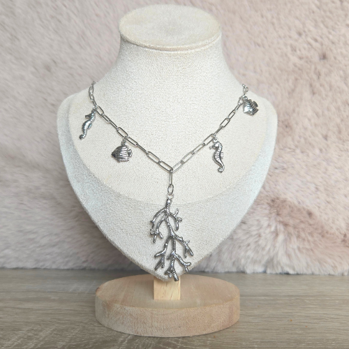 Zilveren oceaan-thema bedelketting met koraal, schelpen en zeepaardjes op sieradendisplay.