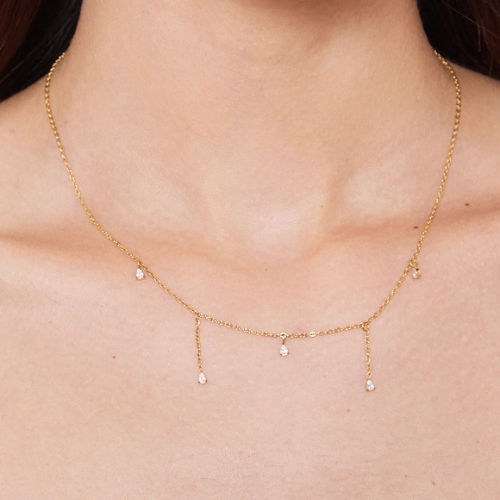 Goudkleurige subtiele ketting met strass steentjes gedragen om de hals