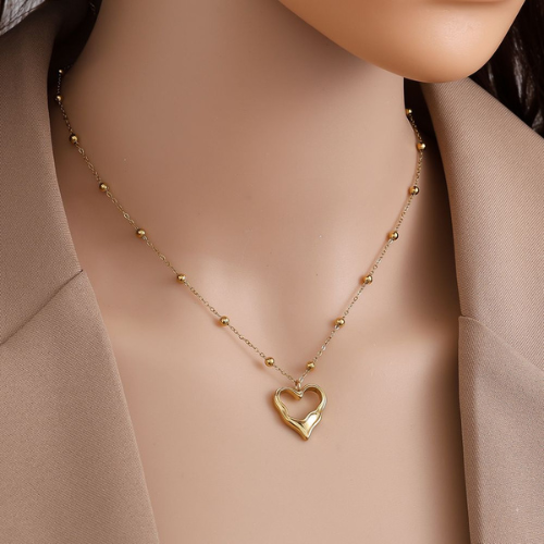 Goudkleurige ketting met bolletjesdesign en uniek, vloeiende hartvormige hanger - van roestvrij staal - gedragen om de hals