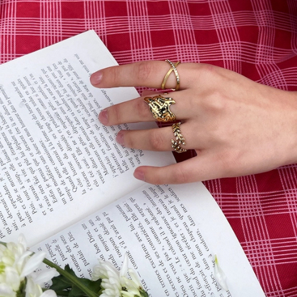 Goudkleurige verstelbare ring ingelegd met zirkonia gecombineerd met andere ringen