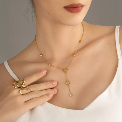 Goudkleurige stainless steel Y-ketting met zirkonia steentjes en klavers ingelegd met zirkonia gedragen om de hals