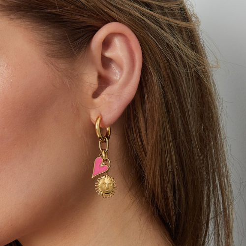 Goudkleurige stainless steel oorbellen met zonnebedel en roze hanger met zirkonia steentje gedragen in het oor