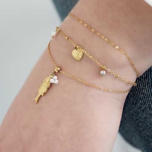Goudkleurige Fishy Armband met visbedel en pareltjes – gelayered met andere minimalistische armbanden