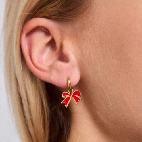 Goudkleurige oorbellen met rode strikjes – elegante en feestelijke statement oorbellen voor dames - gedragen in het oor