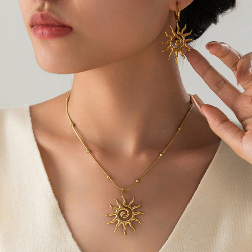 Goudkleurige bolletjesketting met open zon hanger gedragen om de hals gecombineerd met de Horizon oorbellen