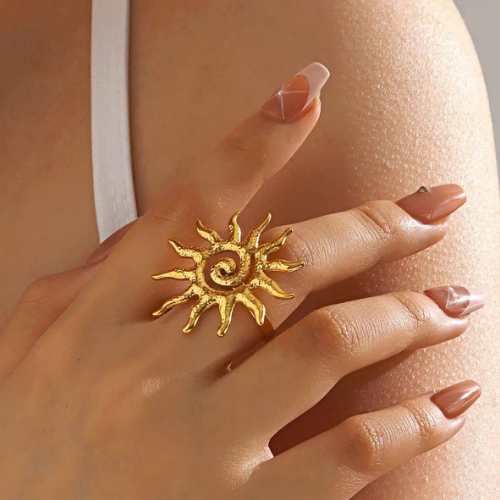 Goudkleurige ring met open zon design gedragen om de middelvinger