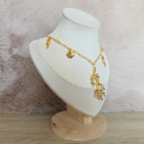 Gouden koraalketting gepresenteerd op een sieradendisplay met zachte achtergrond.