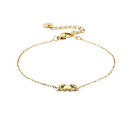 Liggende dunne goudkleurige RVS armband met minimalistisch krabbedel, subtiele beachlook.
