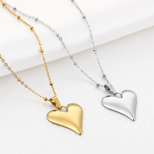 Set van gouden en zilveren kettingen met glanzende hartvormige hangers en fijne bolschakelketting – elegante sieraden voor dames.