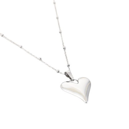 Zilverkleurige damesketting met gepolijste hartvormige hanger en fijne bolschakelketting – elegant en modern sieraad.