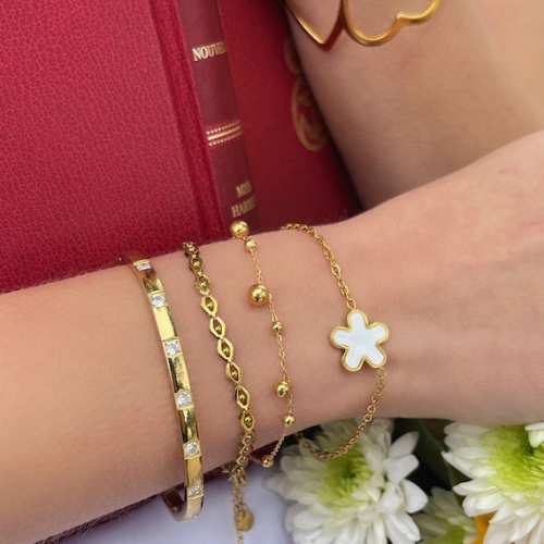 Goudkleurige bolletjes armband gecombineerd met andere armbanden en bangles