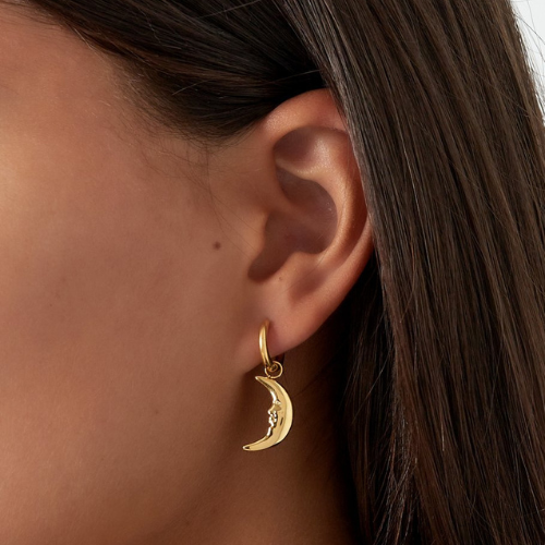 Vrouw draagt goudkleurige maanoorbel met gezichtdetail – stijlvolle en mystieke look voor elke gelegenheid.