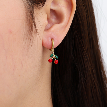 Goudkleurige red cherry oorbellen met rode kersen en groene blaadjes – speelse oorbellen met fruit design in het oor
