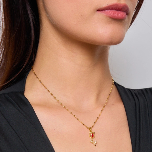 Goudkleurige bloemenketting met rood accent en zirkonia blaadjes gedragen om de hals