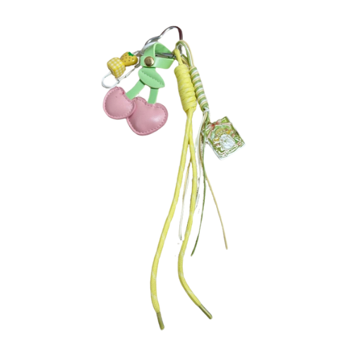 Speelse bagcharm met als hoofdkleur geel en een stoffen roze kers - speelse versiering voor aan je tas