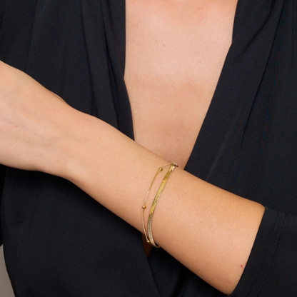 Goudkleurige dubbele damesarmband van stainless steel gedragen om de pols