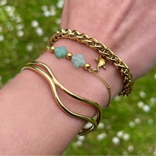 Goudkleurige verstelbare bangle van stainless steel gecombineerd met andere armbanden