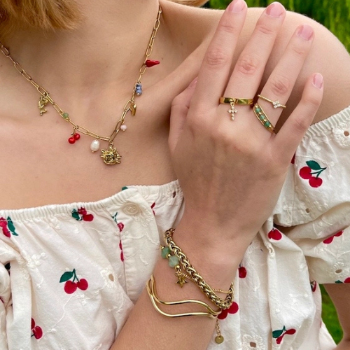 Goudkleurige verstelbare bangle van stainless steel gecombineerd met andere sieraden